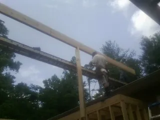 Carpenter setting a ridge beam over a new addition frame — Ice Dam Removal by Roofing Brothers in Huntersville