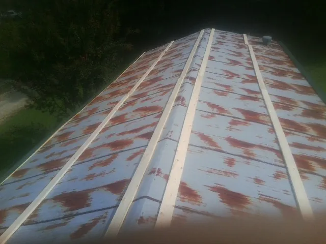 Rusted metal roof panels with new wood purlins before replacement — Storm Damage Roof Repair in Huntersville by Roofing Brothers
