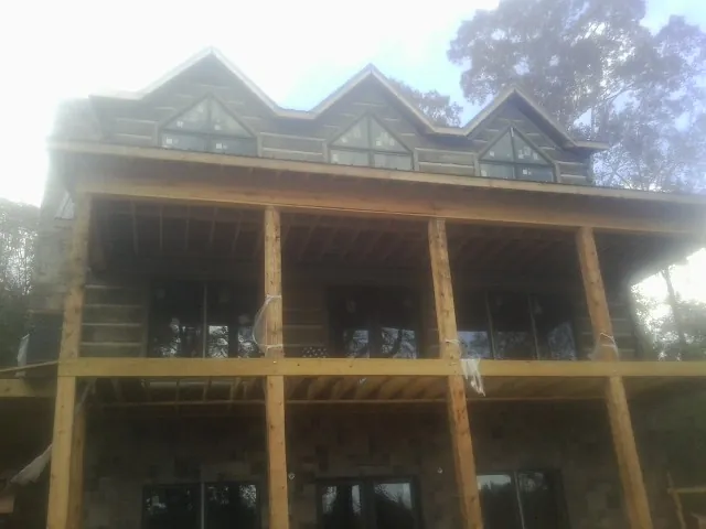 Dormers and porch framing on a large log home under construction — Roof Coating work by our crew in Huntersville
