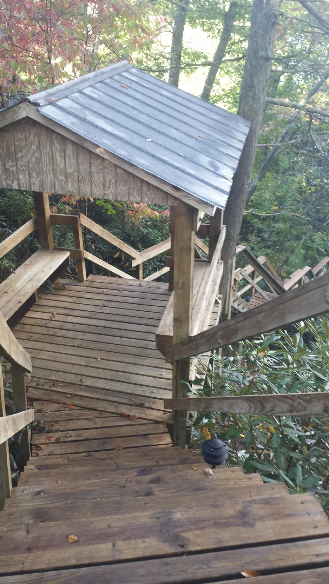 Metal roofed shelter over wooden steps on a wooded walkway — Skylight Repair & Installation work by our crew in Huntersville