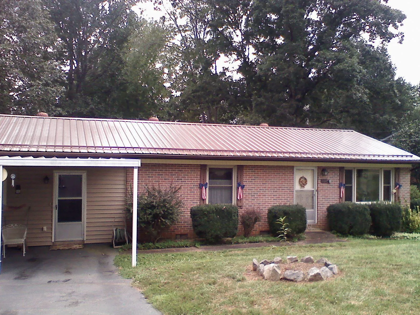 Bronze metal roof and carport on a brick ranch home — Roof Repair work by our crew in Huntersville