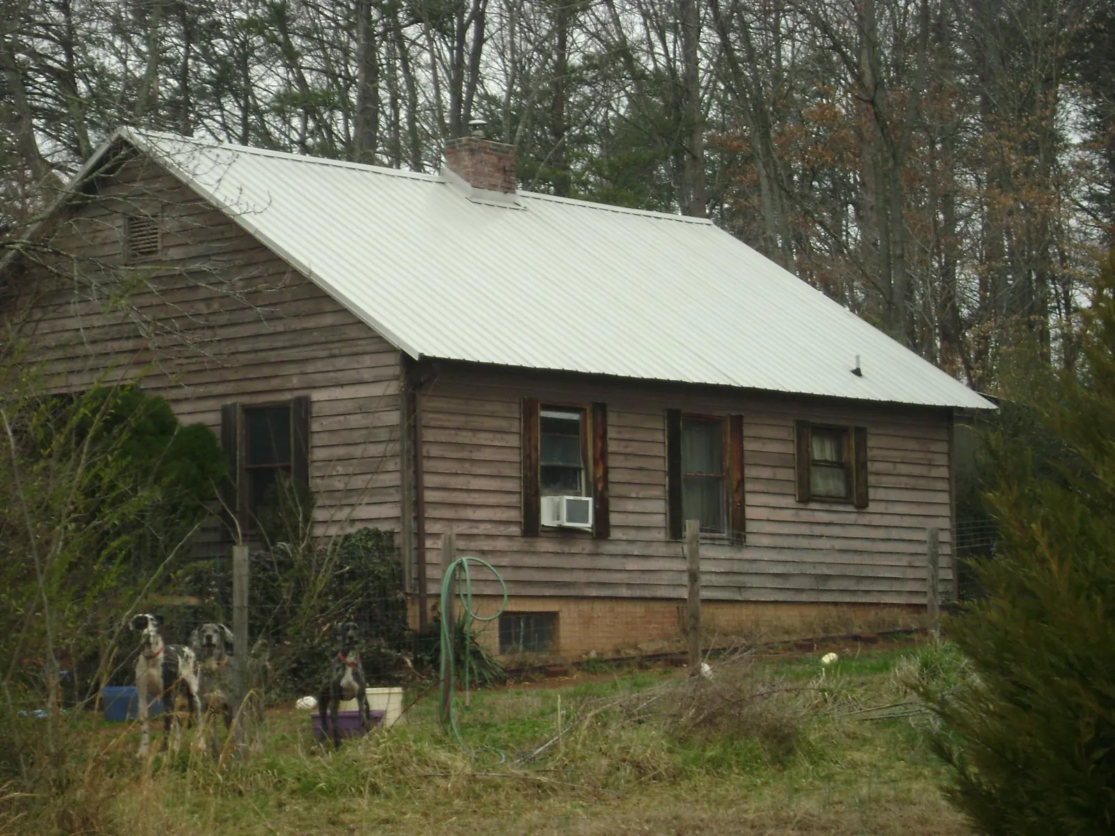 White metal roof on an old wood sided farmhouse, from a Metal Roof Installation job in Huntersville